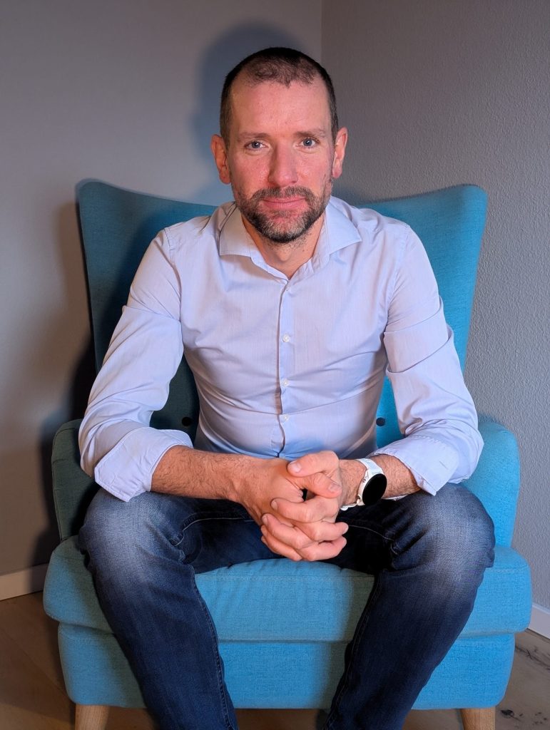 Ein Foto des Gründers auf einem Sessel sitzend.